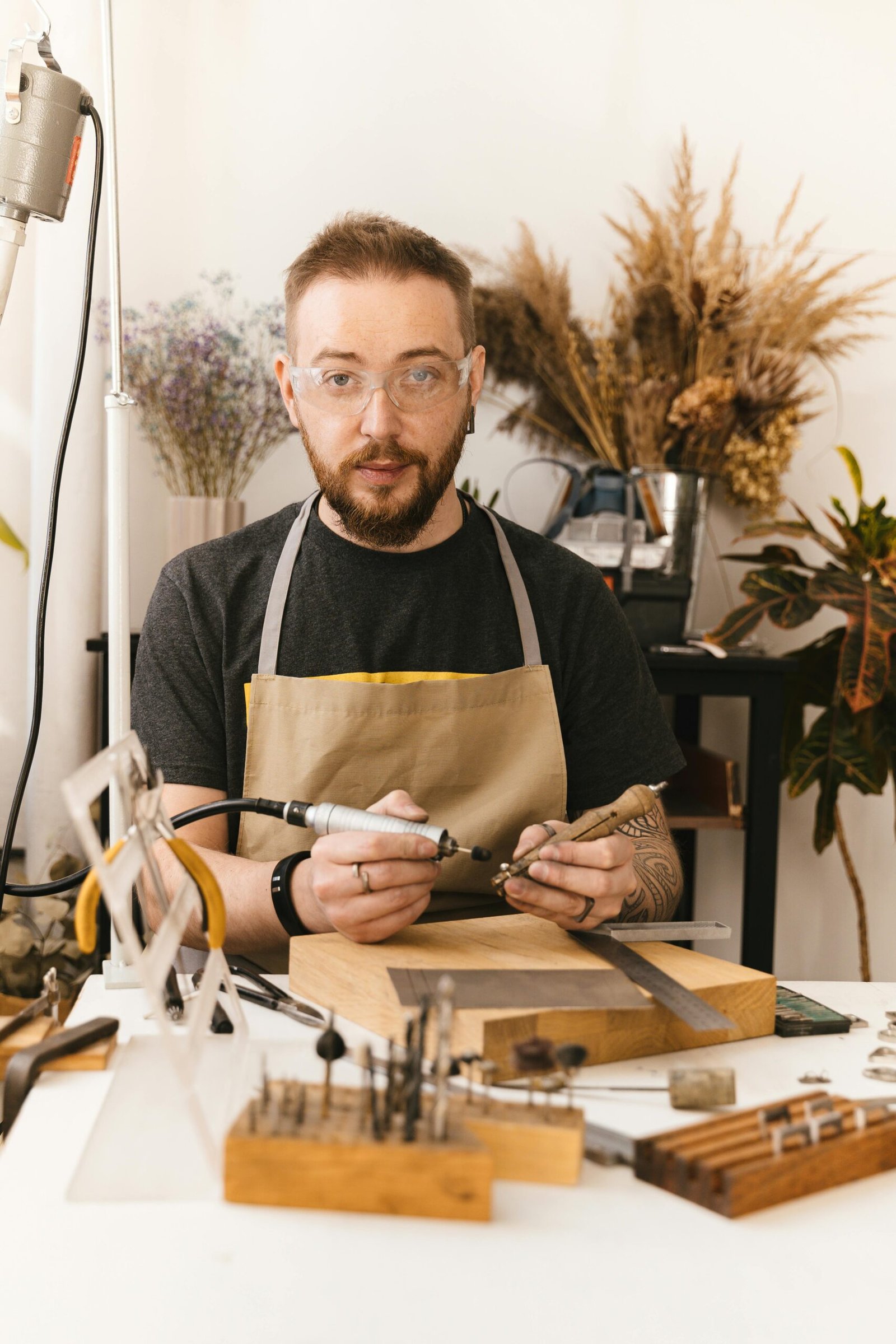 Craftsman jeweller in studio using tools to create intricate designs.
